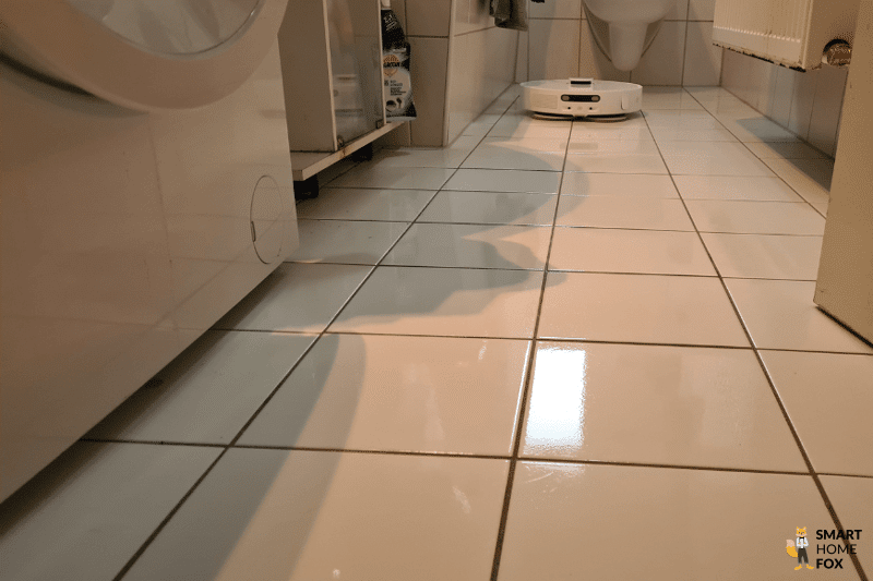 The Dreame L10s Ultra mops a tiled floor in the bathroom.
